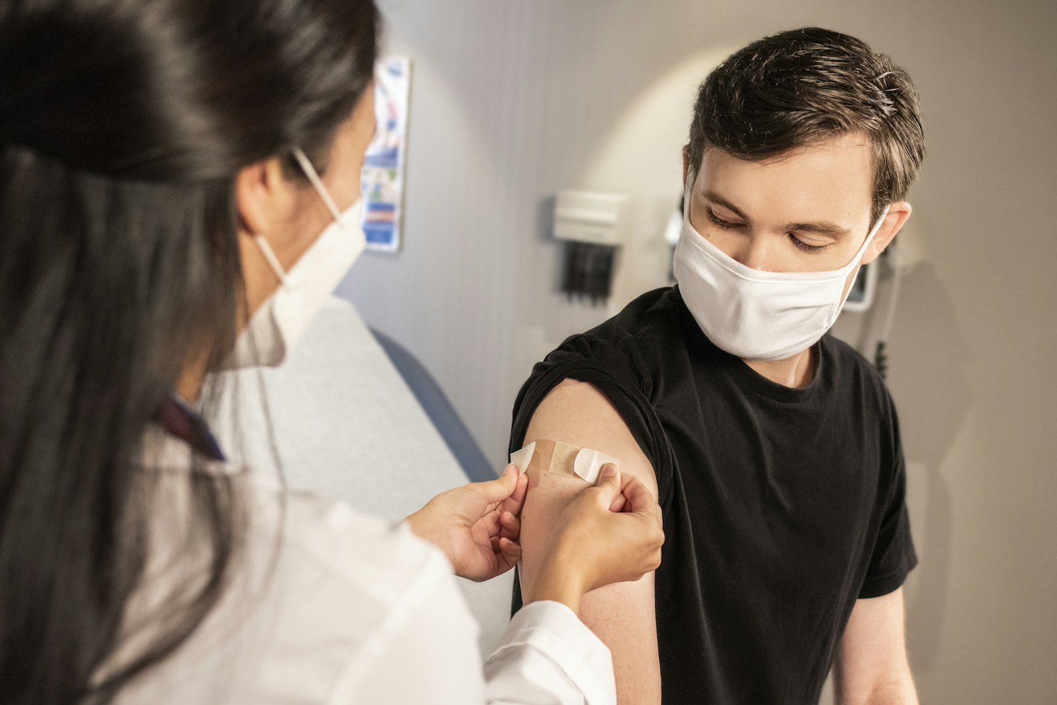 A healthcare professional applies a bandage after a flu vaccination